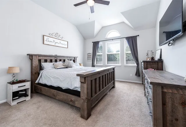 a bedroom with a bed and a flat tv screen on dresser