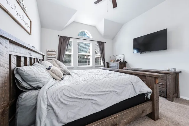 a bedroom with a large bed and a flat screen tv