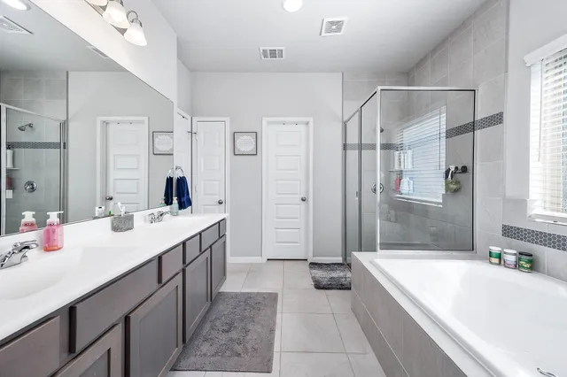 a bathroom with a tub a sink shower and mirror