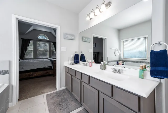 a en suite bathroom with a double vanity sink and a mirror
