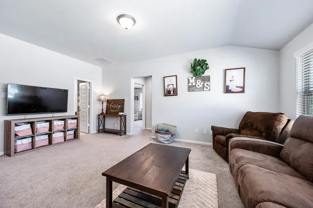 a living room with furniture and a flat screen tv