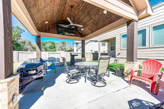 a view of a patio with table and chairs potted plants with wooden floor and floor to ceiling window