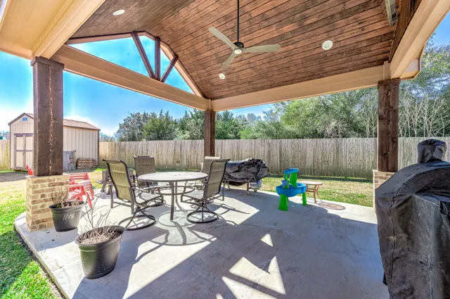 a view of a patio with table and chairs potted plants with wooden floor and fence