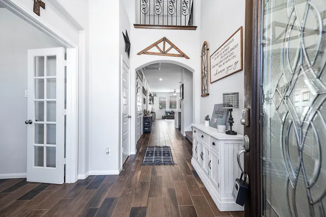 a view of a hallway with wooden floor and a living room