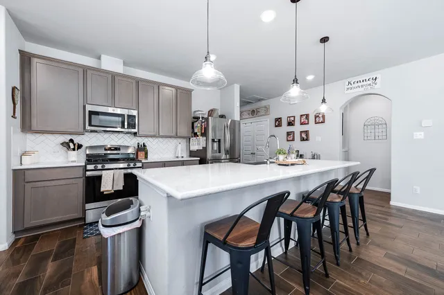 a kitchen with a table chairs microwave and cabinets