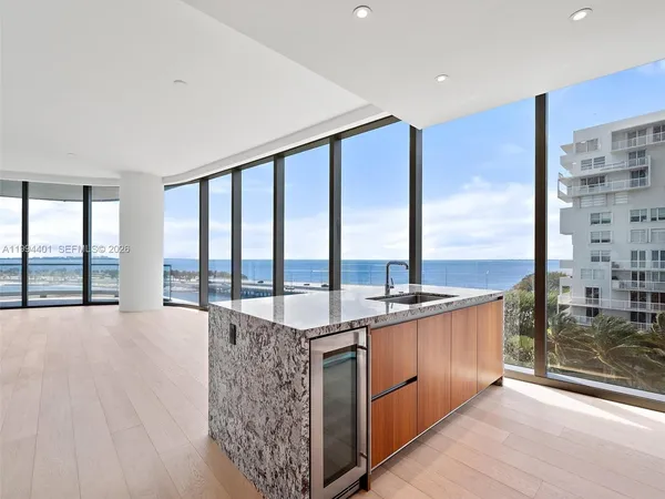 a very nice looking living room with a large window and kitchen view