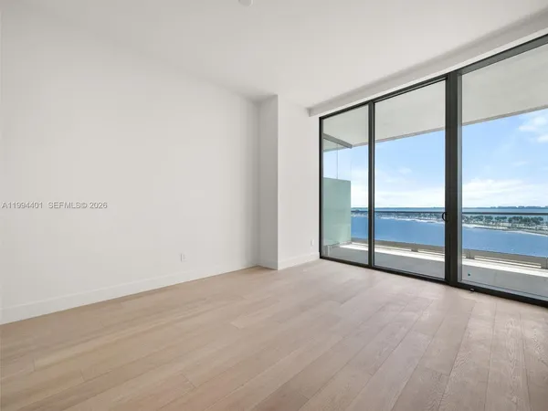 an empty room with wooden floor and sliding door