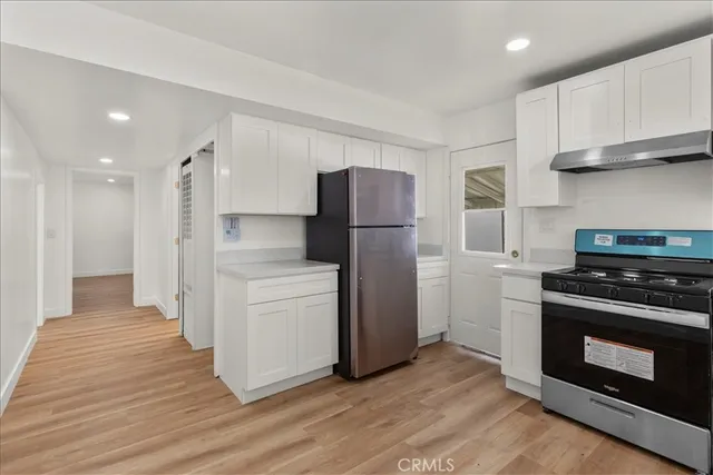 a kitchen with a refrigerator stove and wooden cabinets