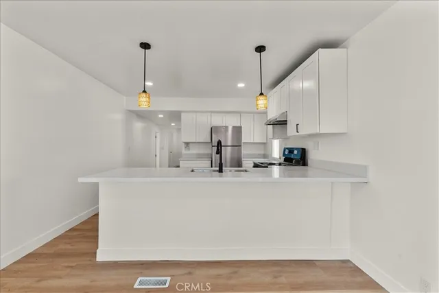 a view of kitchen with stainless steel appliances granite countertop refrigerator