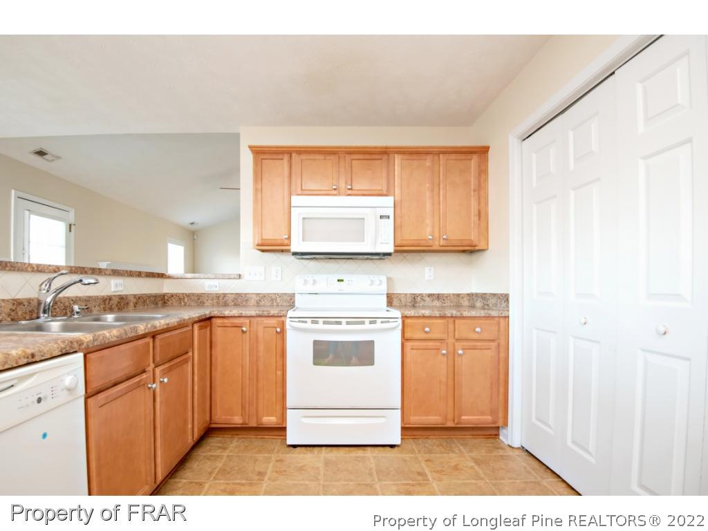 1957 Yellowbrick Road Fayetteville, NC 28314 - Photo 11 of 27 a kitchen with stainless steel appliances granite countertop a stove a sink and a microwave