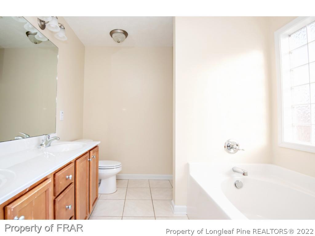 1957 Yellowbrick Road Fayetteville, NC 28314 - Photo 14 of 27 a bathroom with a sink a toilet and shower
