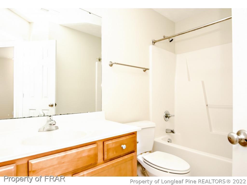 1957 Yellowbrick Road Fayetteville, NC 28314 - Photo 19 of 27 a bathroom with a tub sink and mirror