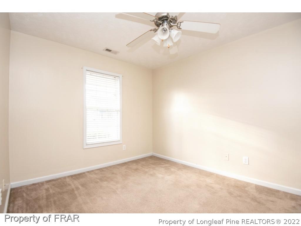 1957 Yellowbrick Road Fayetteville, NC 28314 - Photo 20 of 27 an empty room with windows and chandelier fan