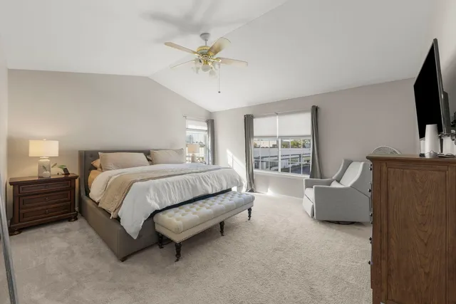 a spacious bedroom with a bed and a flat screen television