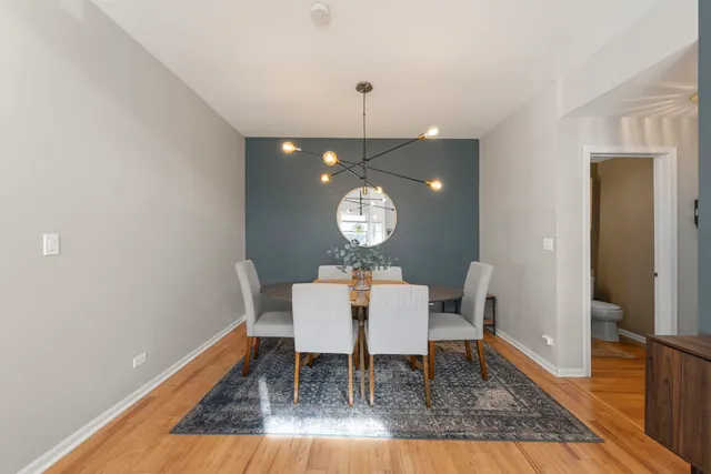 a view of a dining room with furniture a chandelier and wooden floor