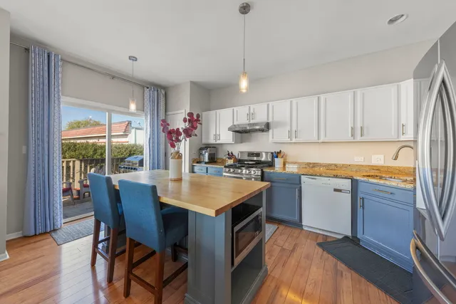 a kitchen with kitchen island granite countertop a sink stove and refrigerator
