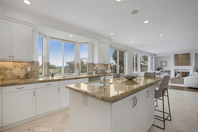 a kitchen with center island white cabinets and stainless steel appliances