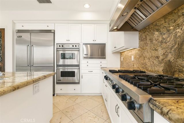 a kitchen with stainless steel appliances granite countertop a stove and a refrigerator