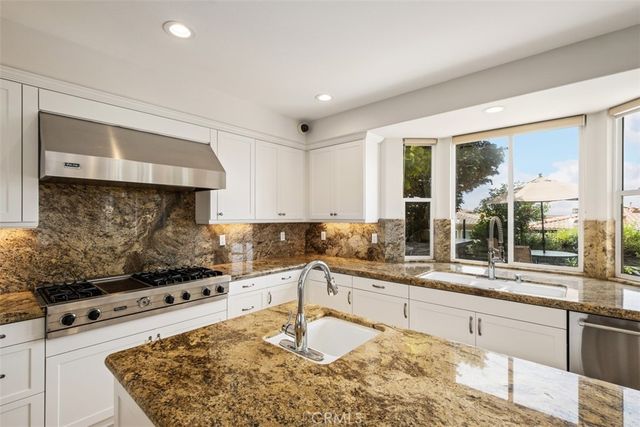 a kitchen with a stove a sink and a wooden cabinets