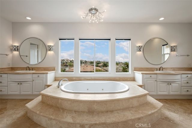 a bathroom with a tub mirror and sink