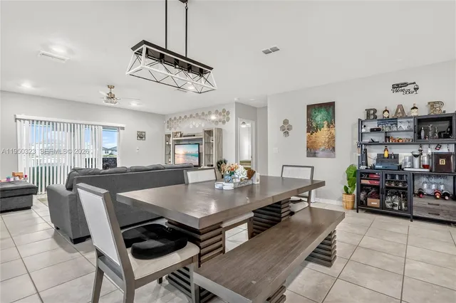a living room with furniture a dining table and chairs with wooden floor