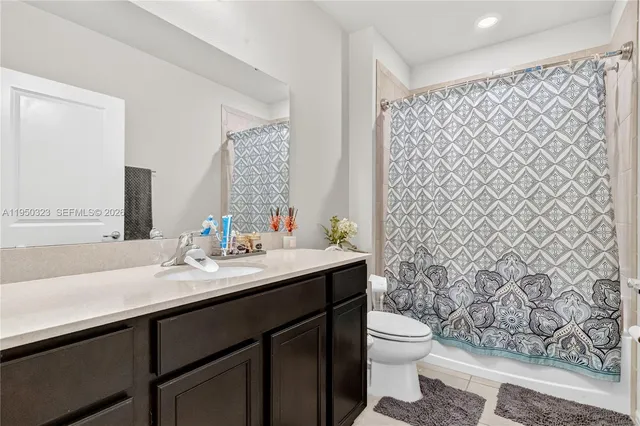 a bathroom with a granite countertop sink a toilet and a mirror
