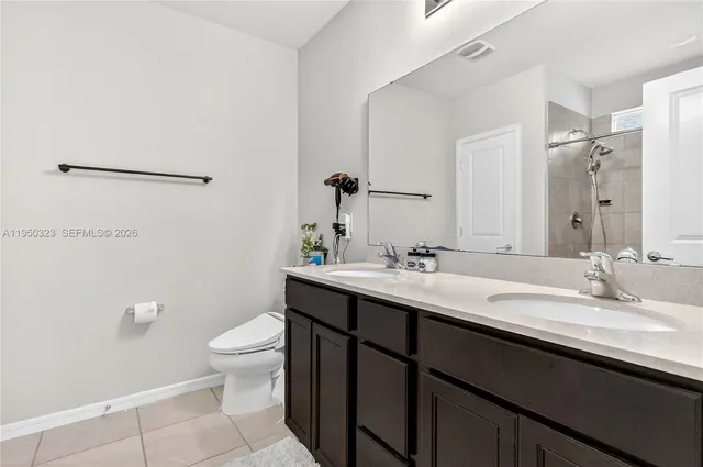 a bathroom with a double vanity sink toilet and a mirror