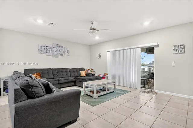 a living room with furniture and a ceiling fan