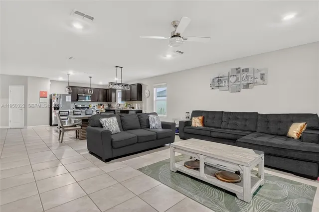 a living room with furniture and kitchen view