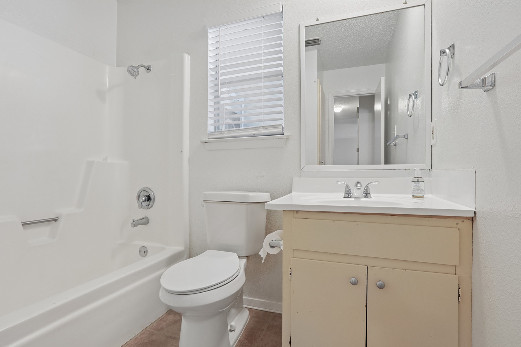3114 Plantation Road, Unit A Austin, TX 78745 - Photo 11 of 15 A well-maintained bathroom offering a standard tub-shower combination, a vanity with ample counter space, and a toilet.