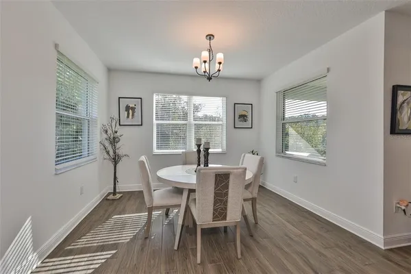 a view of a dining room with furniture a chandelier and wooden floor