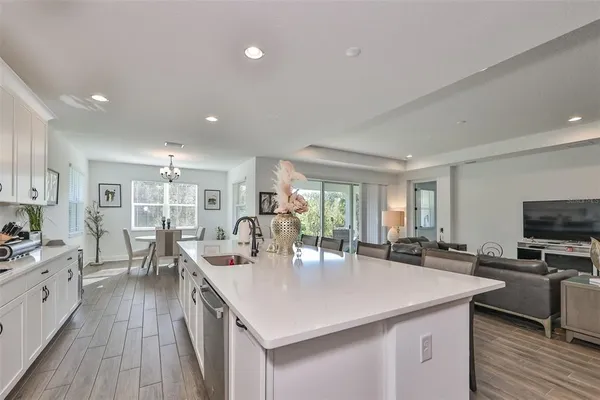 a kitchen with stainless steel appliances a kitchen island hardwood floor sink stove dining table and chairs