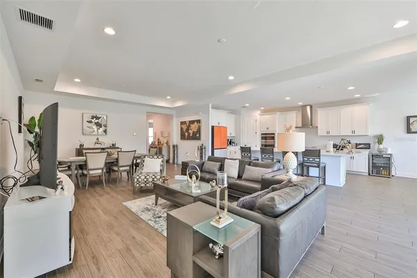 a living room with lots of furniture and kitchen view