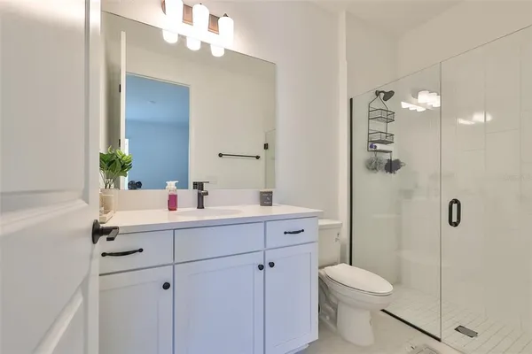 a bathroom with a sink a toilet and shower