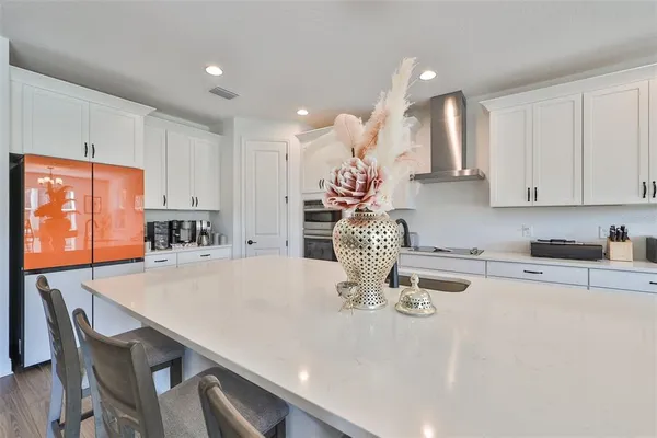 a kitchen with a dining table cabinets and wooden floor