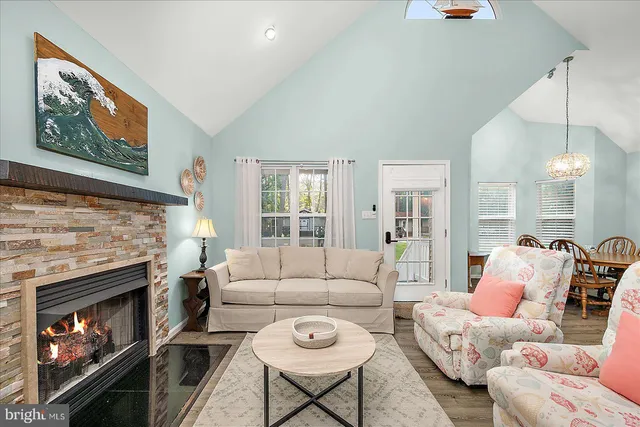 a living room with furniture a flat screen tv and a fireplace