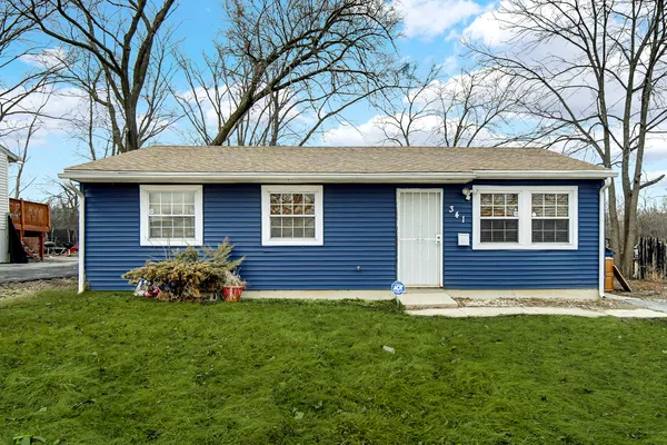 a view of a house with a yard and a large tree