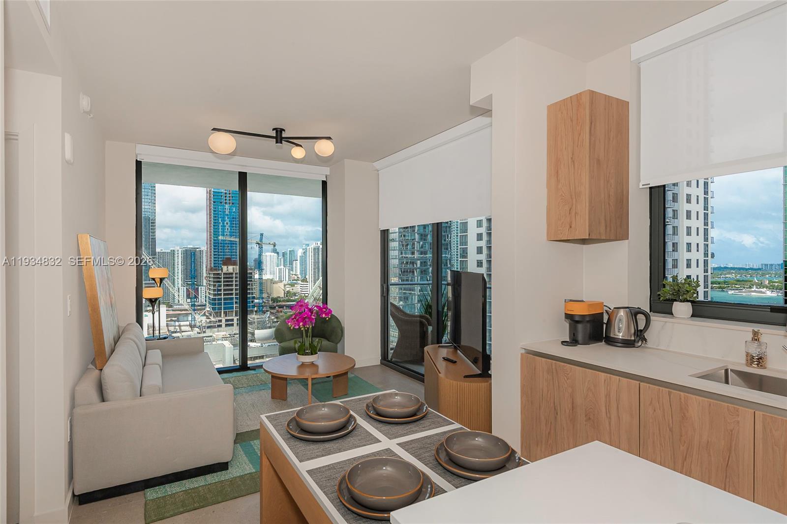 11 Northeast 6th Street, Unit 2709 Miami, FL 33132 - Photo 16 of 39 a living room with furniture and a flat screen tv
