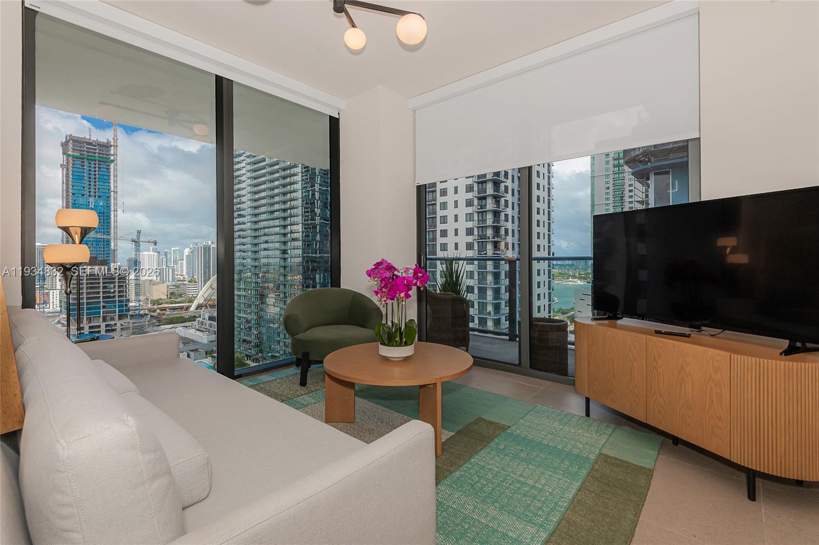 11 Northeast 6th Street, Unit 2709 Miami, FL 33132 - Photo 17 of 39 a living room with furniture and a flat screen tv