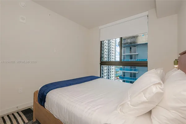 a bedroom with a bed and a window