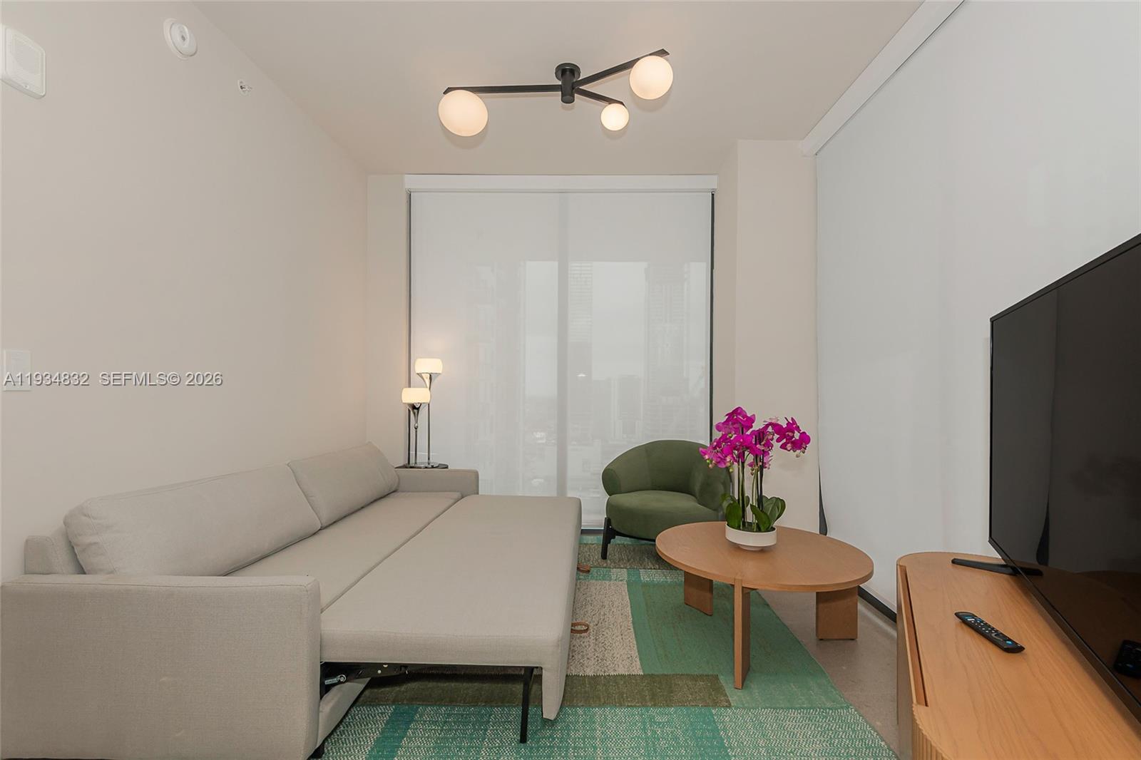 11 Northeast 6th Street, Unit 2709 Miami, FL 33132 - Photo 36 of 39 a living room with furniture a flat screen tv and a window