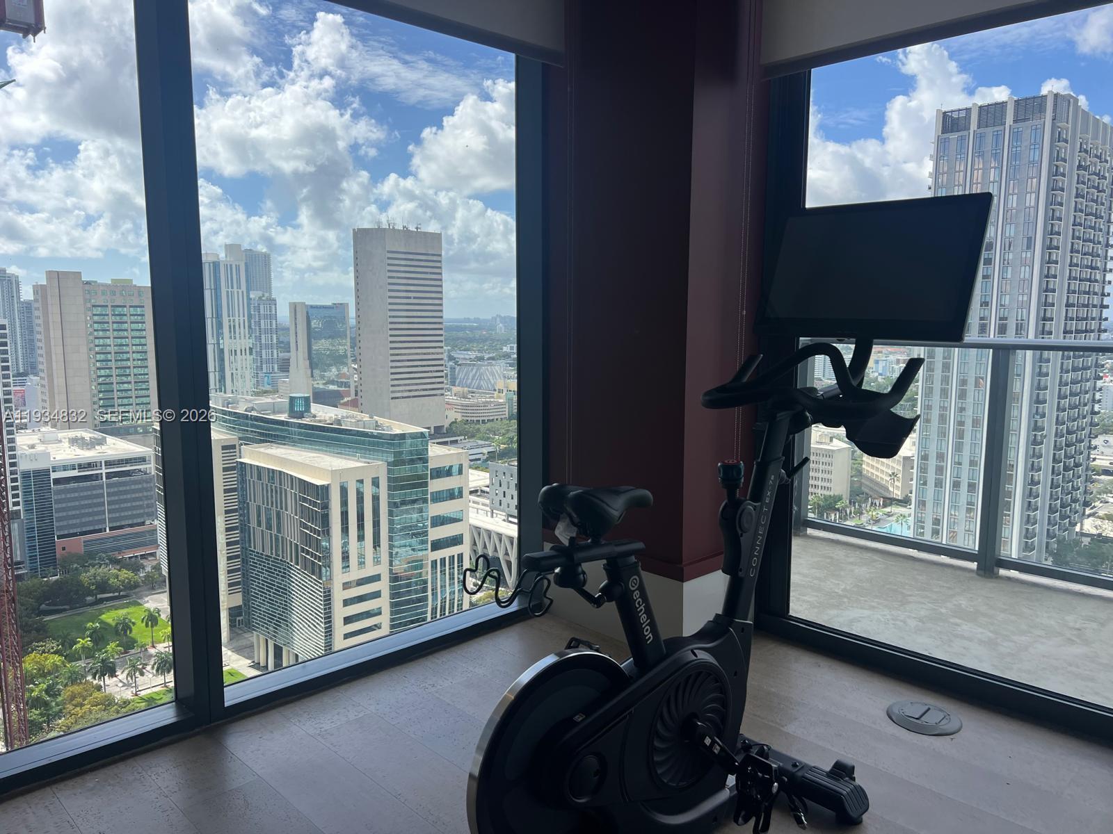 11 Northeast 6th Street, Unit 2709 Miami, FL 33132 - Photo 7 of 39 a room with gym equipment and a large window