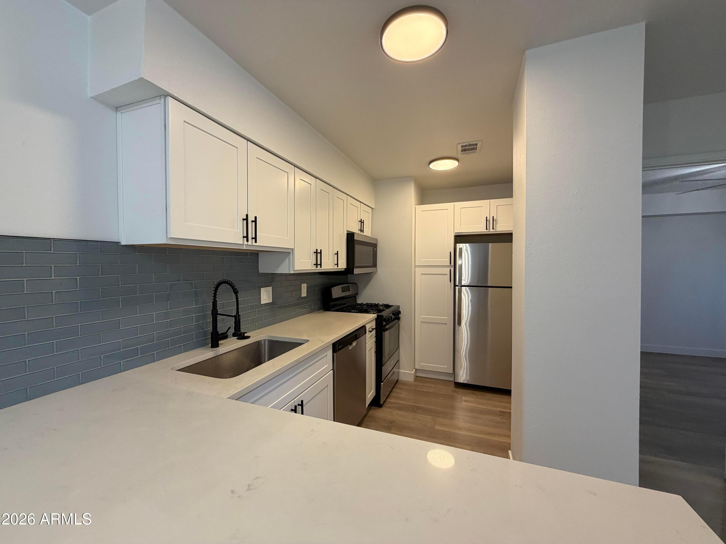 302 East Monte Vista Road, Unit A5 Phoenix, AZ 85004 - Photo 6 of 23 a kitchen with stainless steel appliances granite countertop a sink a refrigerator and a stove