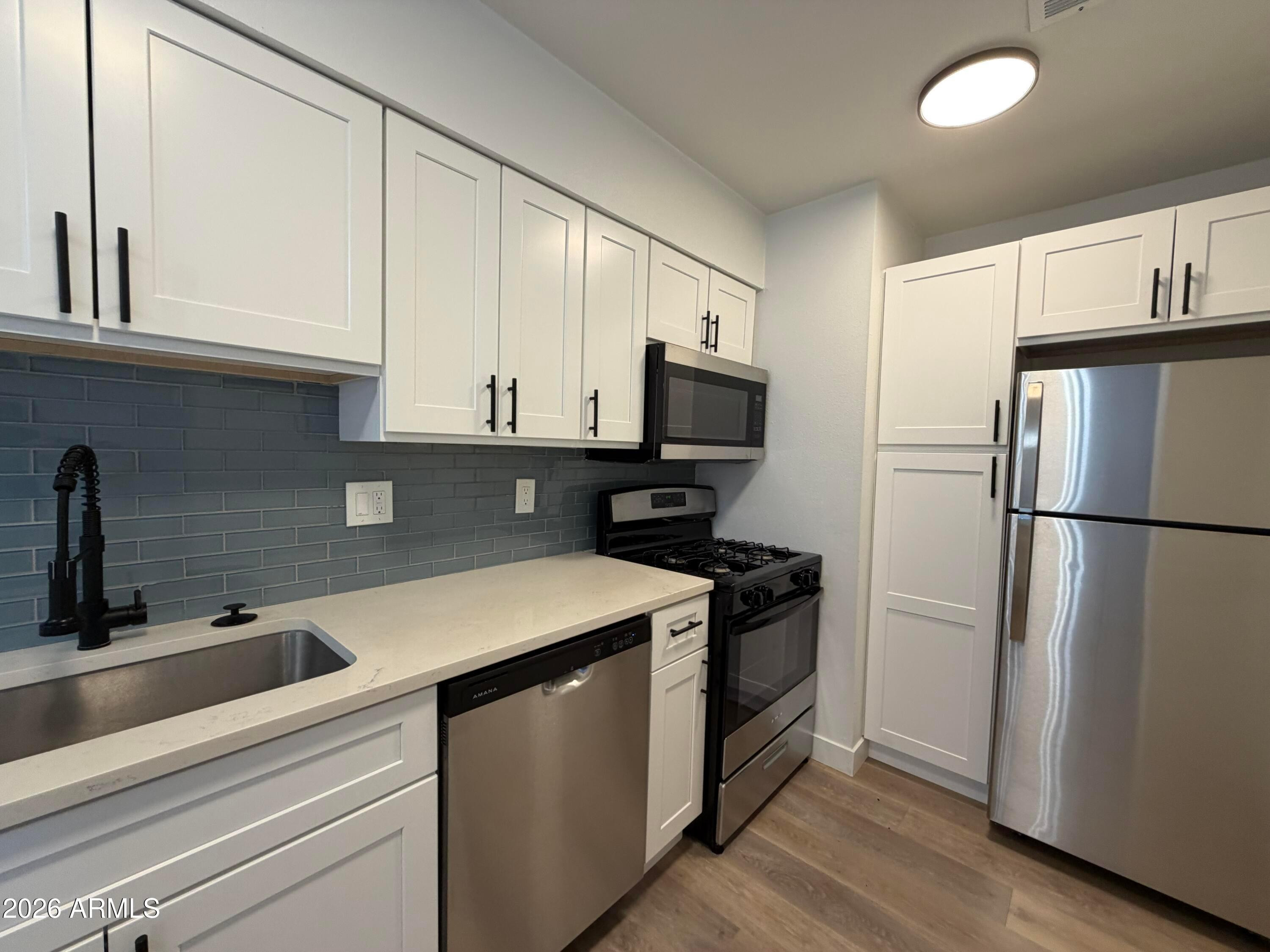 302 East Monte Vista Road, Unit A5 Phoenix, AZ 85004 - Photo 8 of 23 a kitchen with a refrigerator sink and cabinets
