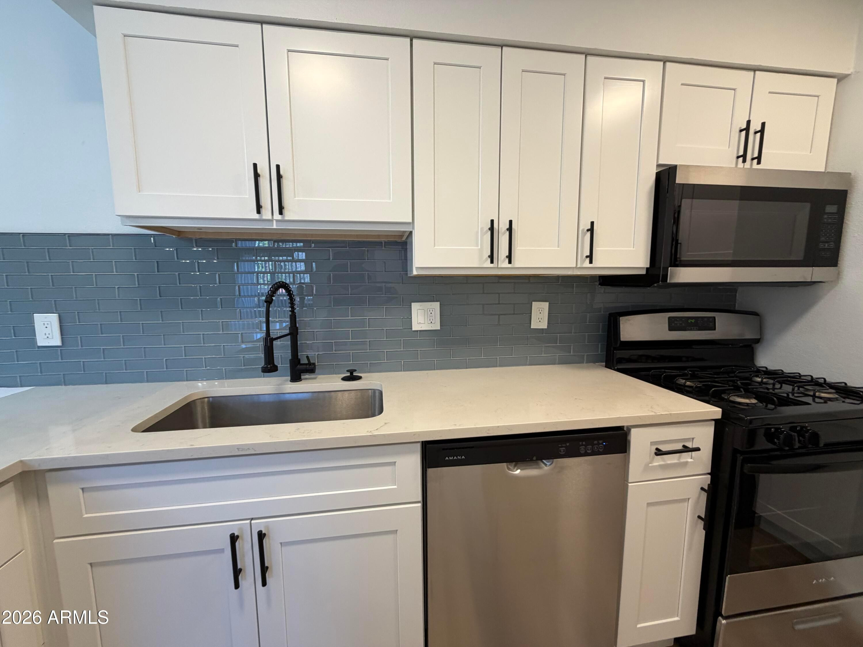 302 East Monte Vista Road, Unit A5 Phoenix, AZ 85004 - Photo 9 of 23 a kitchen with stainless steel appliances granite countertop a sink and a microwave