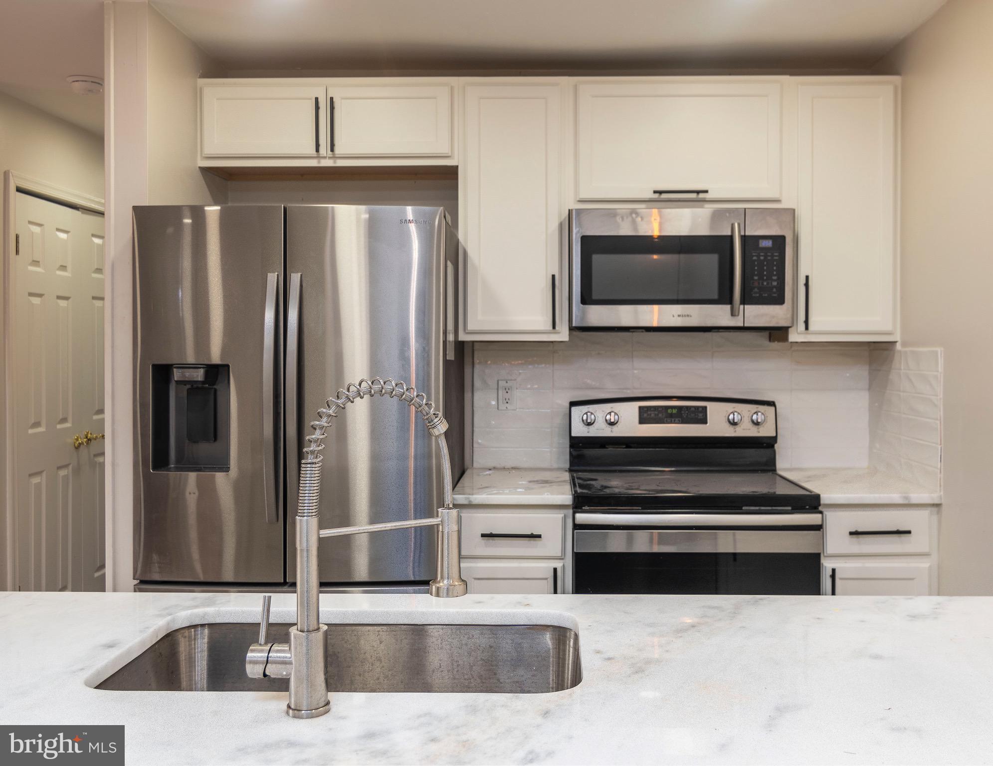 a kitchen with stainless steel appliances a stove a microwave and refrigerator