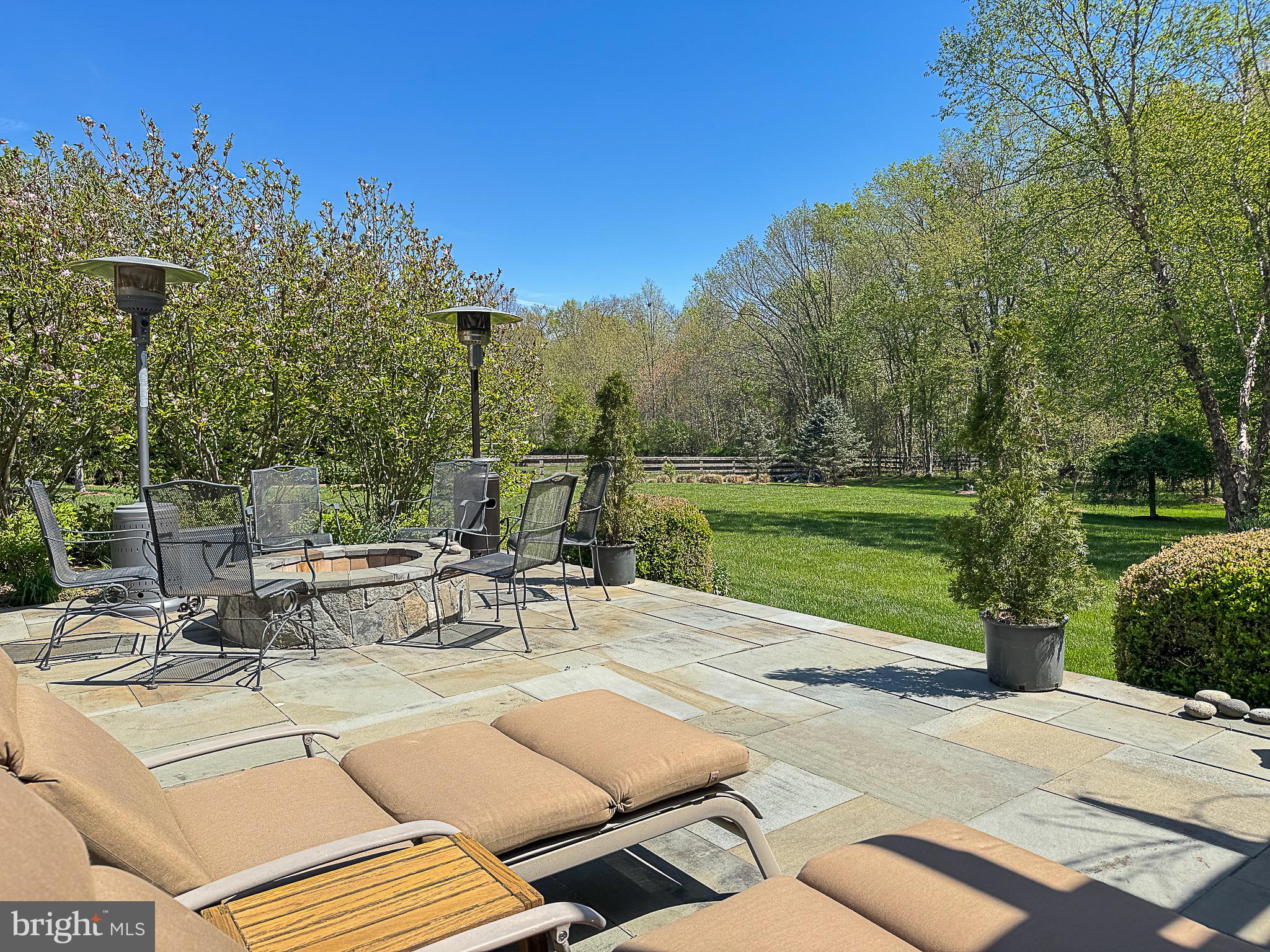 20880 Eckbo Drive Leesburg, VA 20175 - Photo 2 of 10 a view of a patio with a table and chairs under an umbrella with large trees