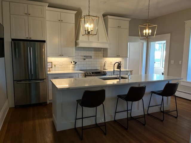 14676 East Twombly Road Rochelle, IL 61068 - Photo 21 of 63 a kitchen with granite countertop a refrigerator a stove a sink and white cabinets with wooden floor