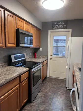 a kitchen with stainless steel appliances granite countertop a stove a sink and a microwave