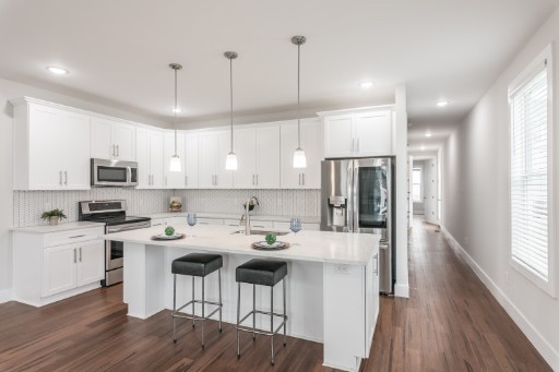 5904 B Morrow Road Nashville, TN 37209 - Photo 2 of 21 a kitchen with stainless steel appliances kitchen island a refrigerator a stove a sink and a dining table with wooden floor